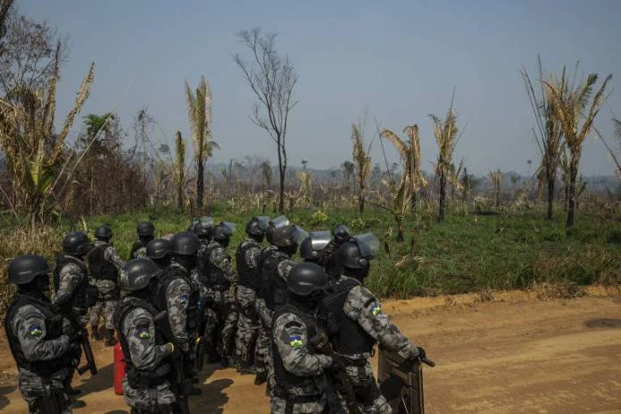 Tropa de choque da PM caminha por estrada dentro da Floresta Nacional Bom Futuro em Rondônia