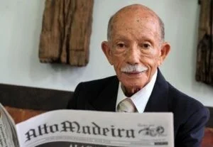Um homem administra uma vacina a uma criança segurada por uma mulher
