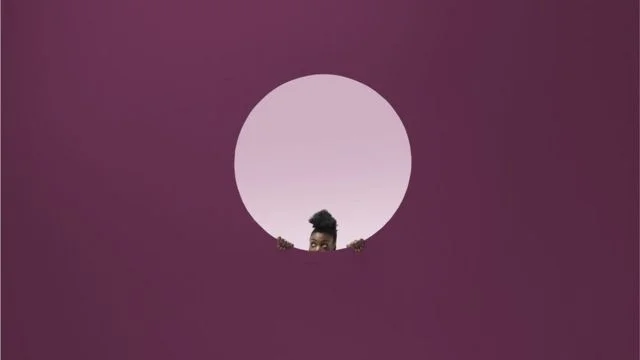 Ilustração de mulher espreitando algo em fundo cor de rosa