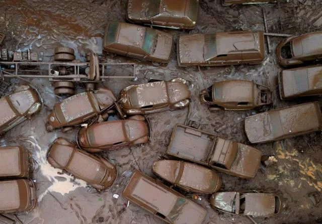 Foto aerea mostra carros cobertos por lama na rua