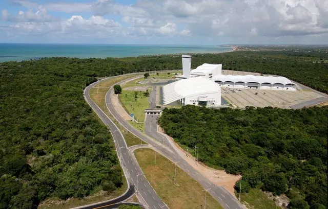 Foto aérea de avenida rodeada por mata e uma construção