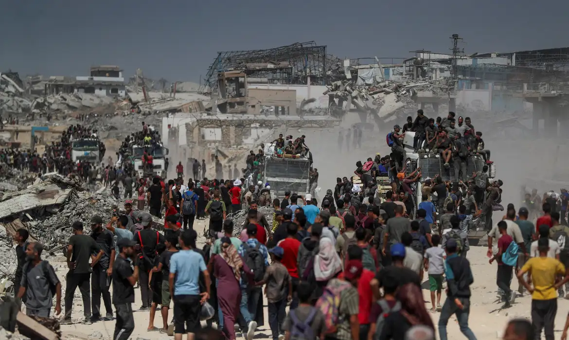 Palestinos carregam ajuda em Beit Lahia, norte de Gaza 1/8/2025 REUTERS/Mahmoud Issa