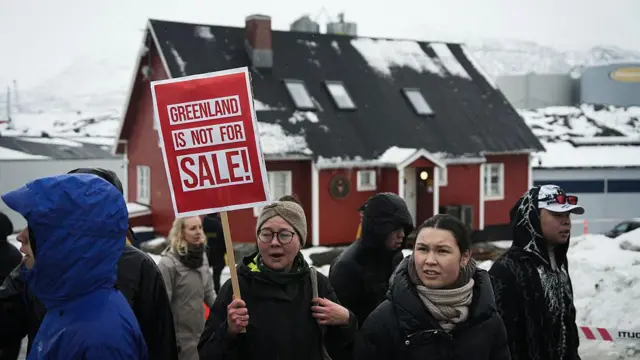 Pessoas com cartazes e bandeiras da Groenlândia se reúnem perto do Consulado dos Estados Unidos na capital groenlandesa, Nuuk, para protestar