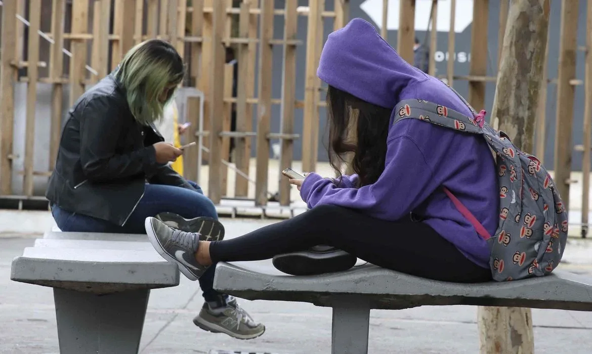  Uso contínuo de celular com  a cabeça inclinada para baixo pode gerar problemas na cervical.