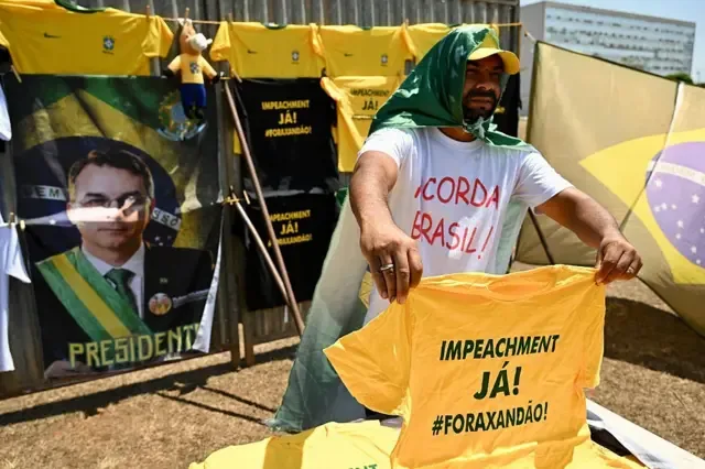 Manifestante segura camisa amarela dizendo "impeachment já! #foraxandão"